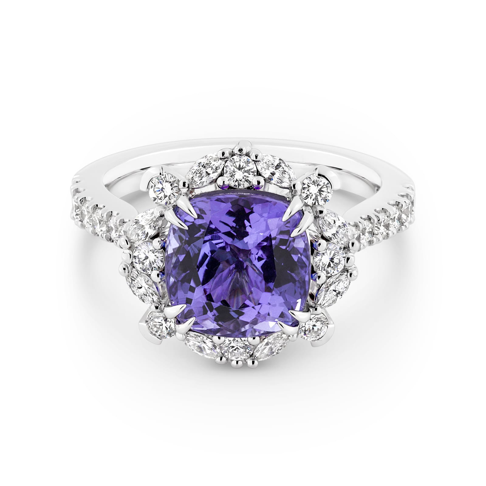 Violetta has a 4.06 carat cushion-cut tanzanite centre surrounded by a halo of alternating white round brilliant cut and marquise cut diamonds. Featuring 2 marquise cut diamonds underneath the ring and 14 round white diamonds on the band. She was designed and handcrafted by LeGassick's Master Jewellers, Gold Coast, Australia.