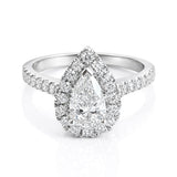 Diamond ring with a pear-shaped centre stone and diamond halo on a white background