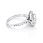Diamond ring with a pear-shaped centre stone and diamond halo on a white background