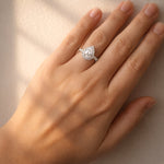 Diamond ring with a pear-shaped centre stone and diamond halo on a lady's hand