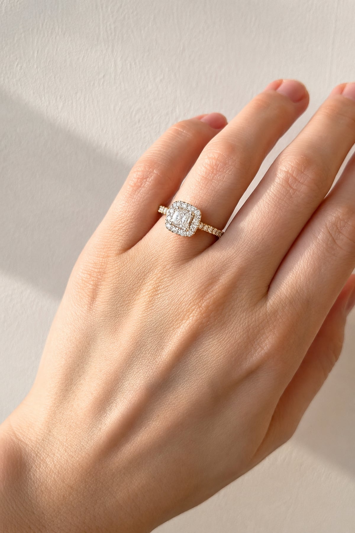 Hand wearing a Princess Cut Diamond Ring set in 18ct Two-Tone Gold on a beige background.