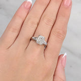 Hand wearing a diamond ring with a light grey background at LeGassick.
