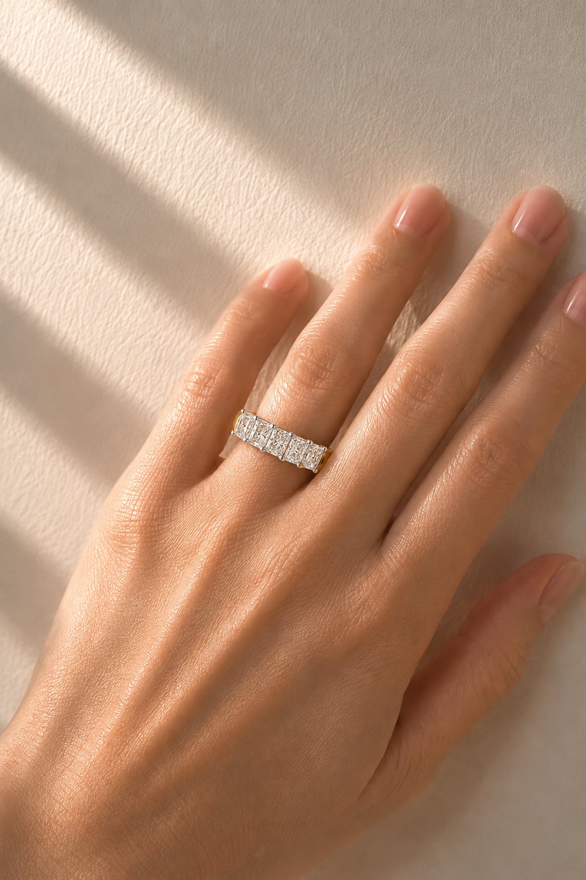 5 Stone gold and lab diamond ring on a a lady's hand