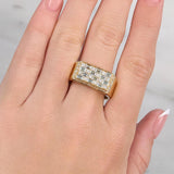 Gold ring with diamonds on a hand against a neutral background at LeGassick showroom