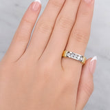 Hand wearing a gold and silver ring on a neutral background at LeGassick.