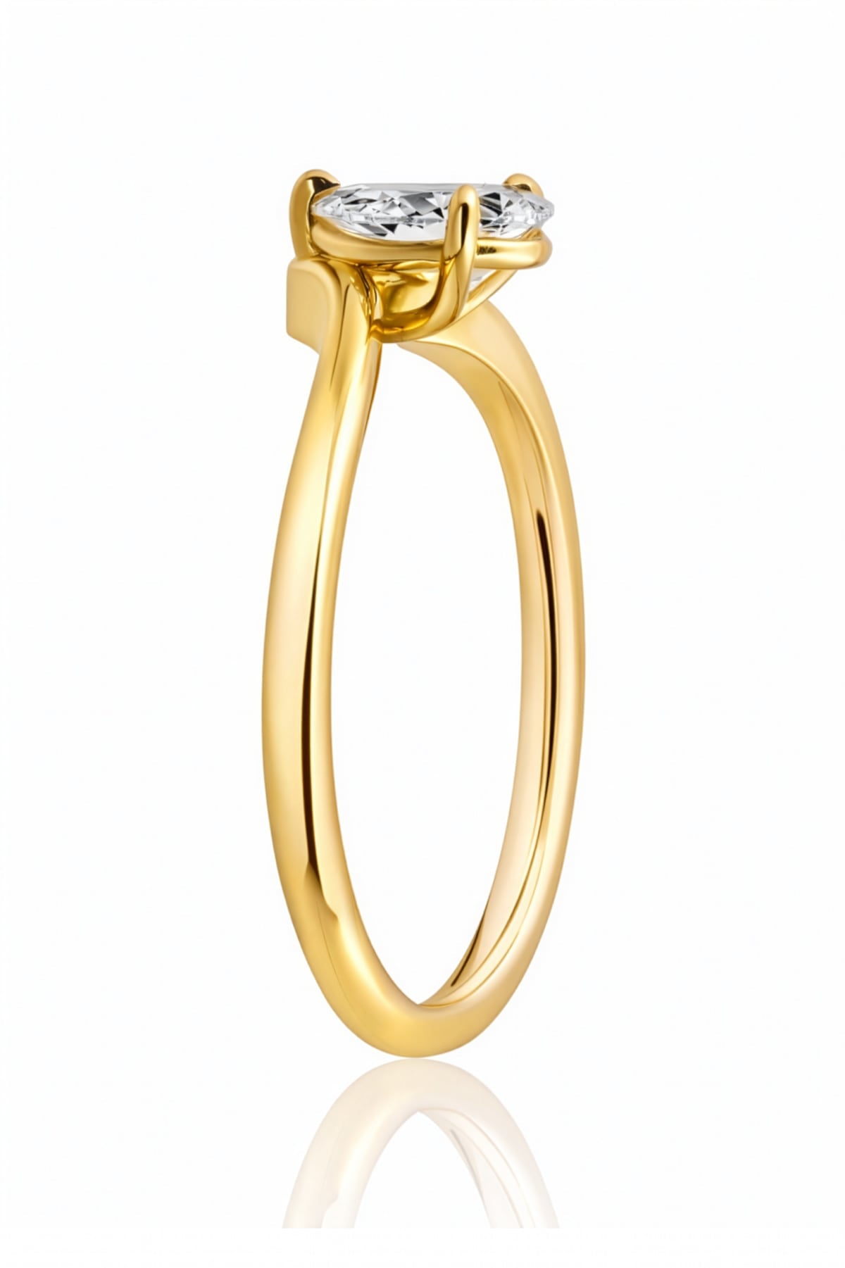Gold ring with a pear-shaped diamond on a white background