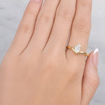 hand wearing old ring with a pear-shaped diamond on a white background