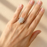 Hand wearing a diamond dress ring on a beige background