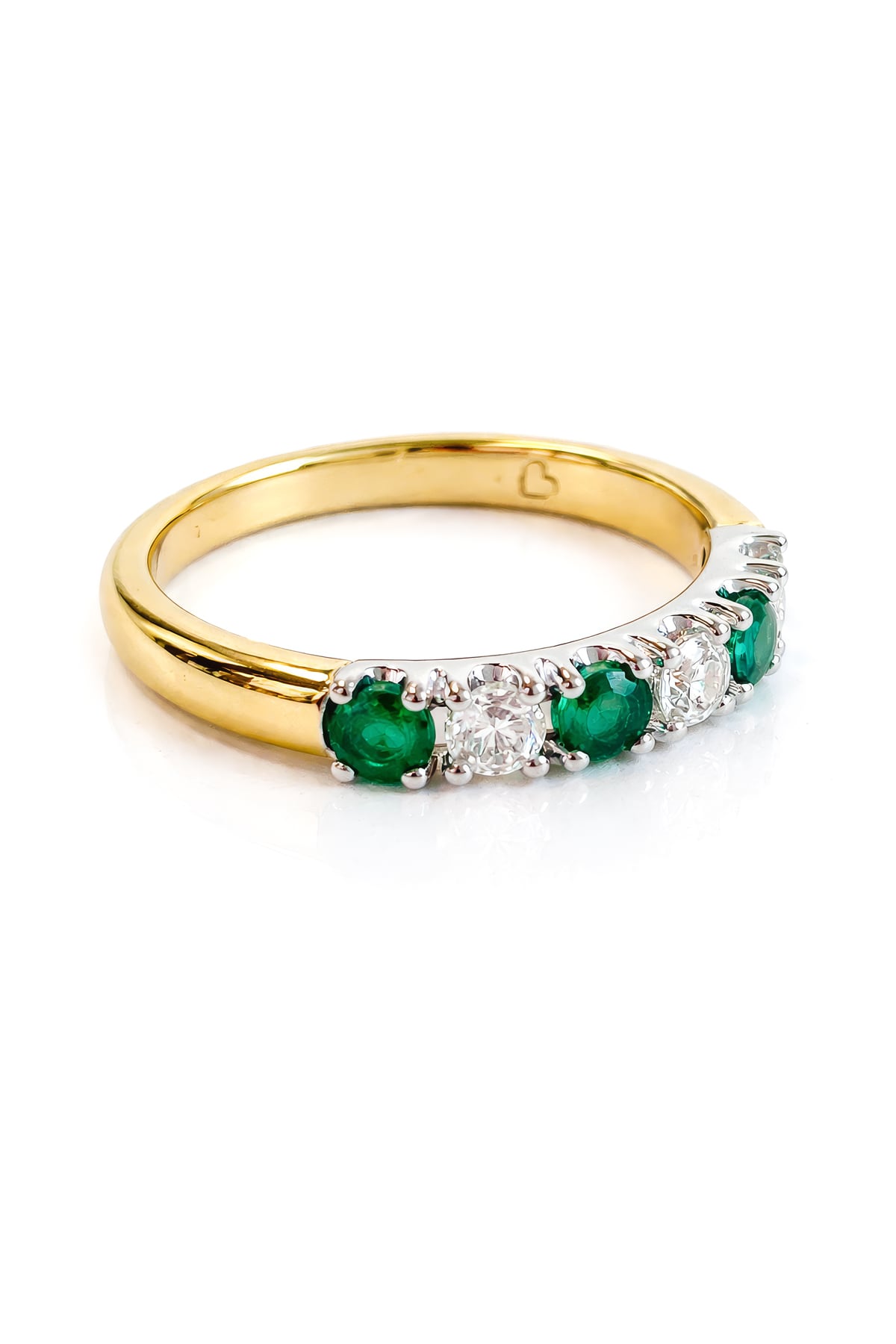 Gold ring with emeralds and diamonds on a white background