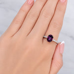 Hand wearing a ring with a purple gemstone on a light background at LeGassick Showroom.