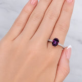 Hand wearing a ring with a purple gemstone on a light background at LeGassick Showroom.