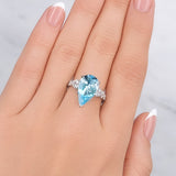Lady's hand wearing a Pear Aquamarine & Diamond Ring set in 18ct White Gold at LeGassick.