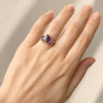 Hand wearing a Amethyst Toi et Moi Yellow Gold Ring on beige background