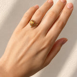 Hand wearing a Pear Cut Bezel Set Citrine Ring in Yellow Gold on a light background