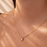 Gold necklace with a diamond teardrop pendant on a person's neck at LeGassick