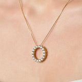 Necklace with a circular pendant on a person's neck
