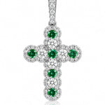 A white gold cross pendant featuring a central cluster of round green emeralds surrounded by pavé-set clear diamonds, shown on a white background with a soft reflection.