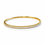 Gold bangle with diamonds on a white background