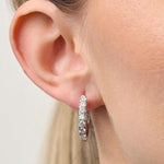 Lady wearing 18ct White Gold Diamond Set Oval Huggie Earrings