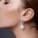 Close-up of a woman wearing a diamond drop earring with a dark background at LeGassick.
