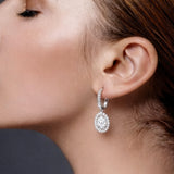 Close-up of a woman wearing a diamond drop earring with a dark background at LeGassick.