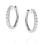 Pair of white gold hoop earrings with clear diamonds on a white background