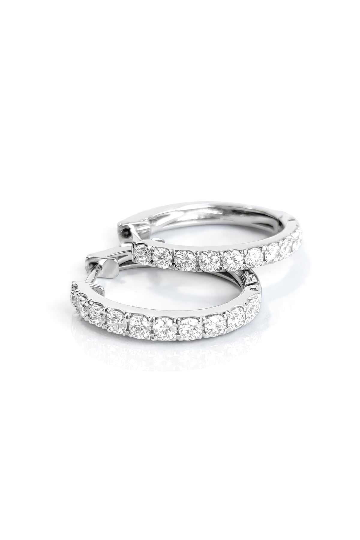 Pair of white gold hoop earrings with clear diamonds on a white background
