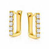 A pair of gold huggie hoop earrings with a vertical row of round-cut clear diamonds on the front, set against a plain white background.