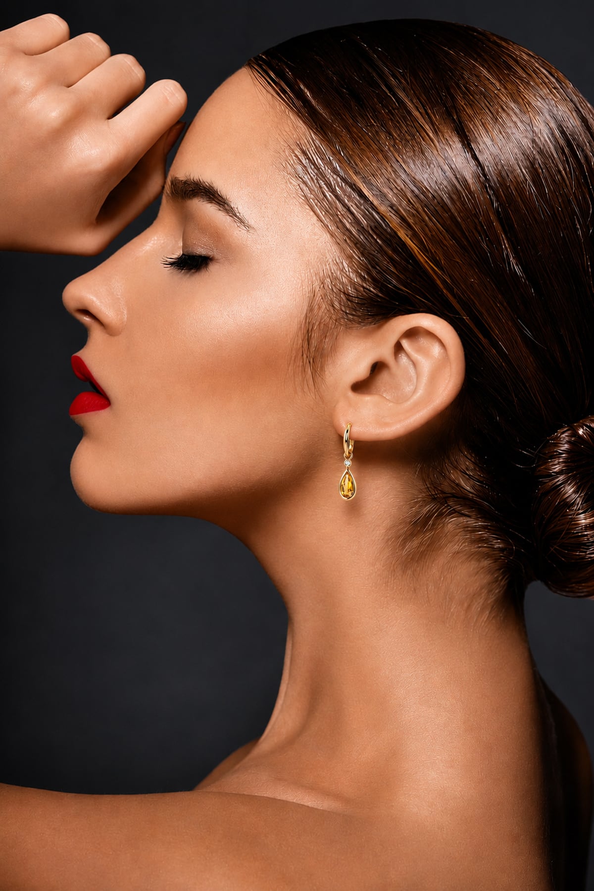 Lady wearing Citrine & Diamond Drop Earrings in Yellow Gold on a grey background