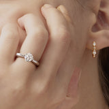 Close-up of a woman wearing a silver ring and gold earrings.