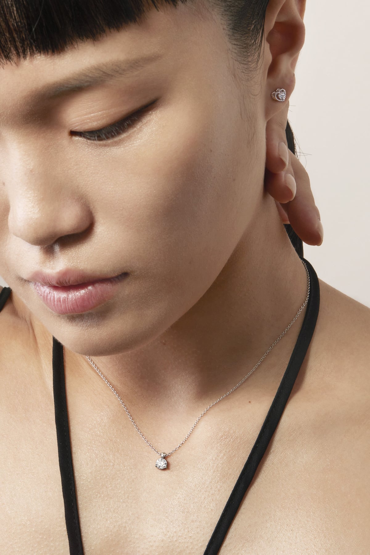 Close-up of a person wearing a delicate necklace with a small pendant.