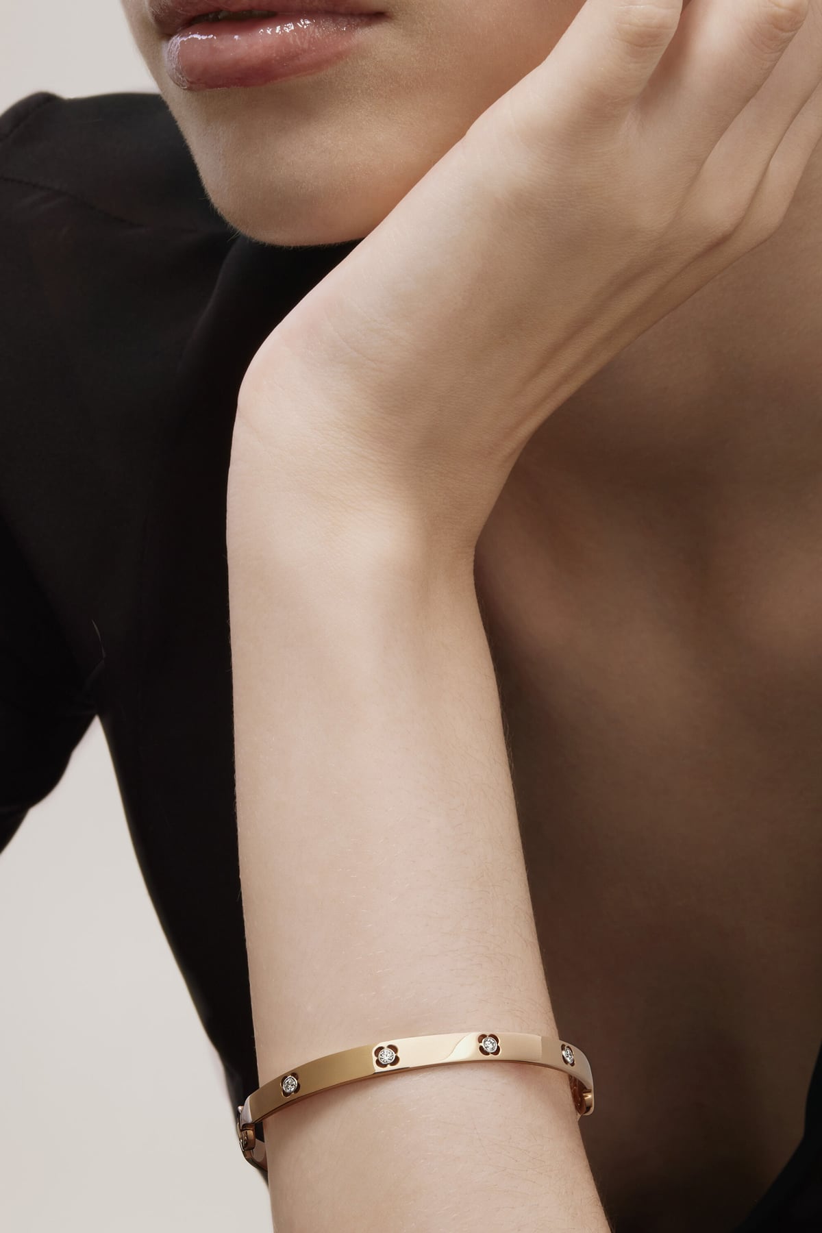 Rose gold bracelet on a person's wrist with a neutral background