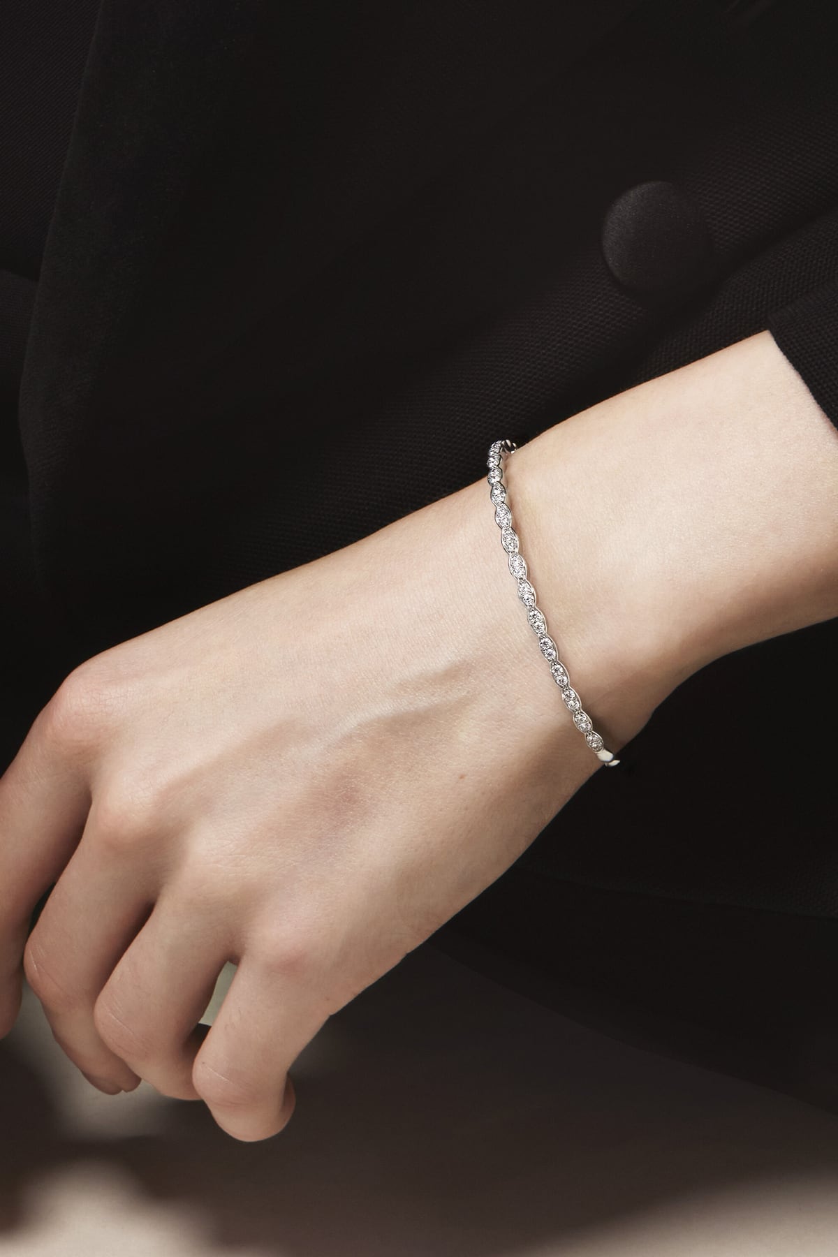 Silver bracelet on a wrist with a dark background