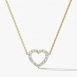 Gold necklace with a heart-shaped diamond pendant on a white background