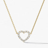 Gold necklace with a heart-shaped diamond pendant on a white background