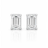 A pair of emerald-cut diamond stud earrings in a white gold setting, displayed on a clean white background with a soft reflection below.
