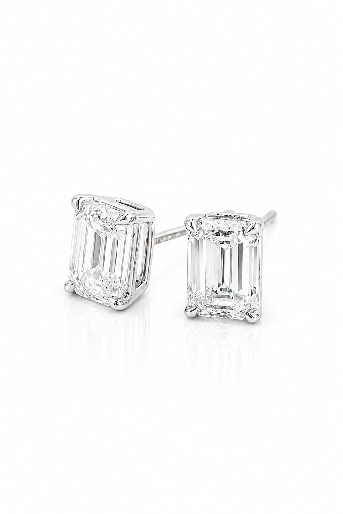 A pair of white gold stud earrings featuring rectangular emerald-cut clear diamonds in four-prong settings, shown on a clean white background.