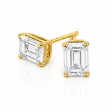 A pair of yellow gold stud earrings featuring rectangular emerald-cut clear diamonds in four-prong settings, shown on a clean white background.