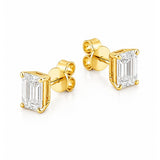 A pair of yellow gold stud earrings featuring rectangular emerald-cut clear diamonds in four-prong settings, shown on a clean white background.