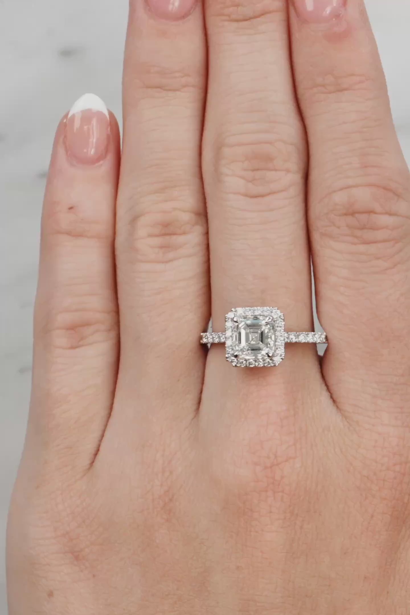 Hand wearing a diamond ring on a neutral background at LeGassick.