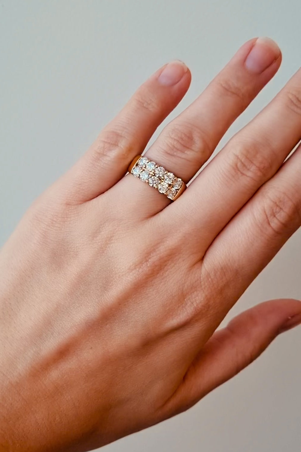 Hearts on fire gold ring with diamond stones on a light background