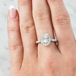 Lady wearing a 0.70ct Oval Diamond Halo Ring in 18ct White Gold