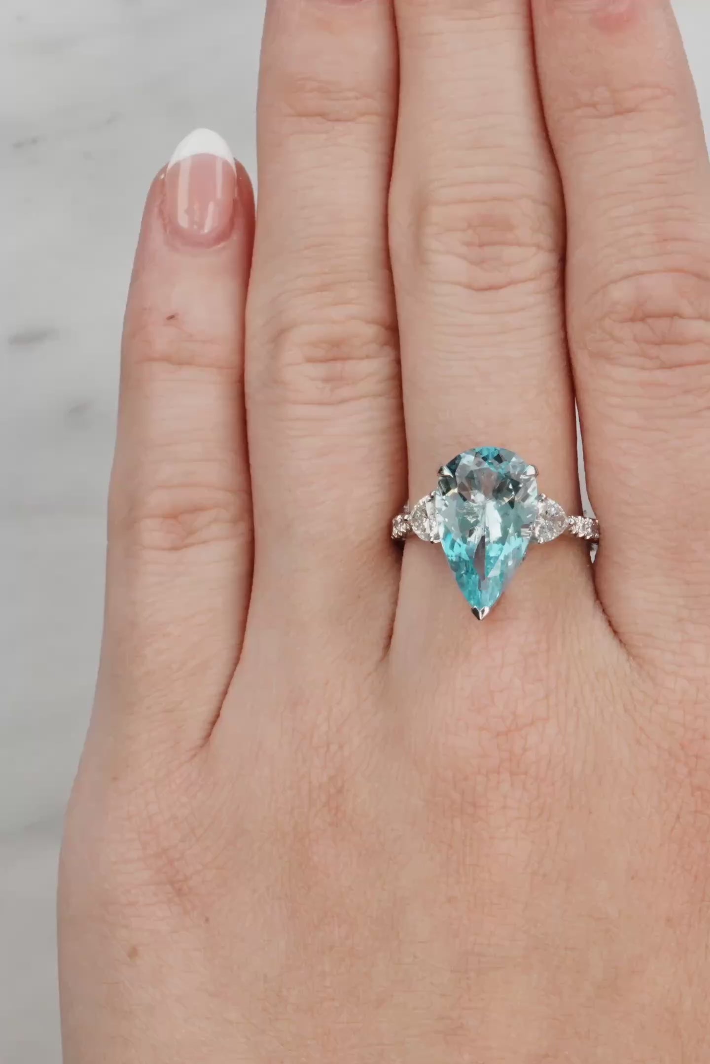 Lady's hand wearing a Pear Aquamarine & Diamond Ring set in 18ct White Gold at LeGassick.