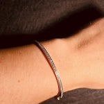 White Gold diamond bracelet on a wrist against a neutral background