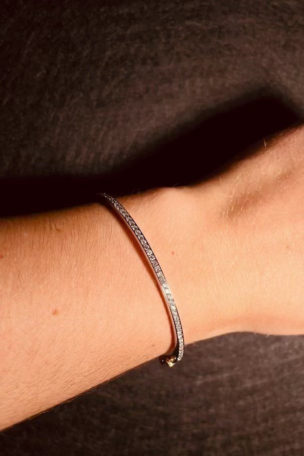 White Gold diamond bracelet on a wrist against a neutral background