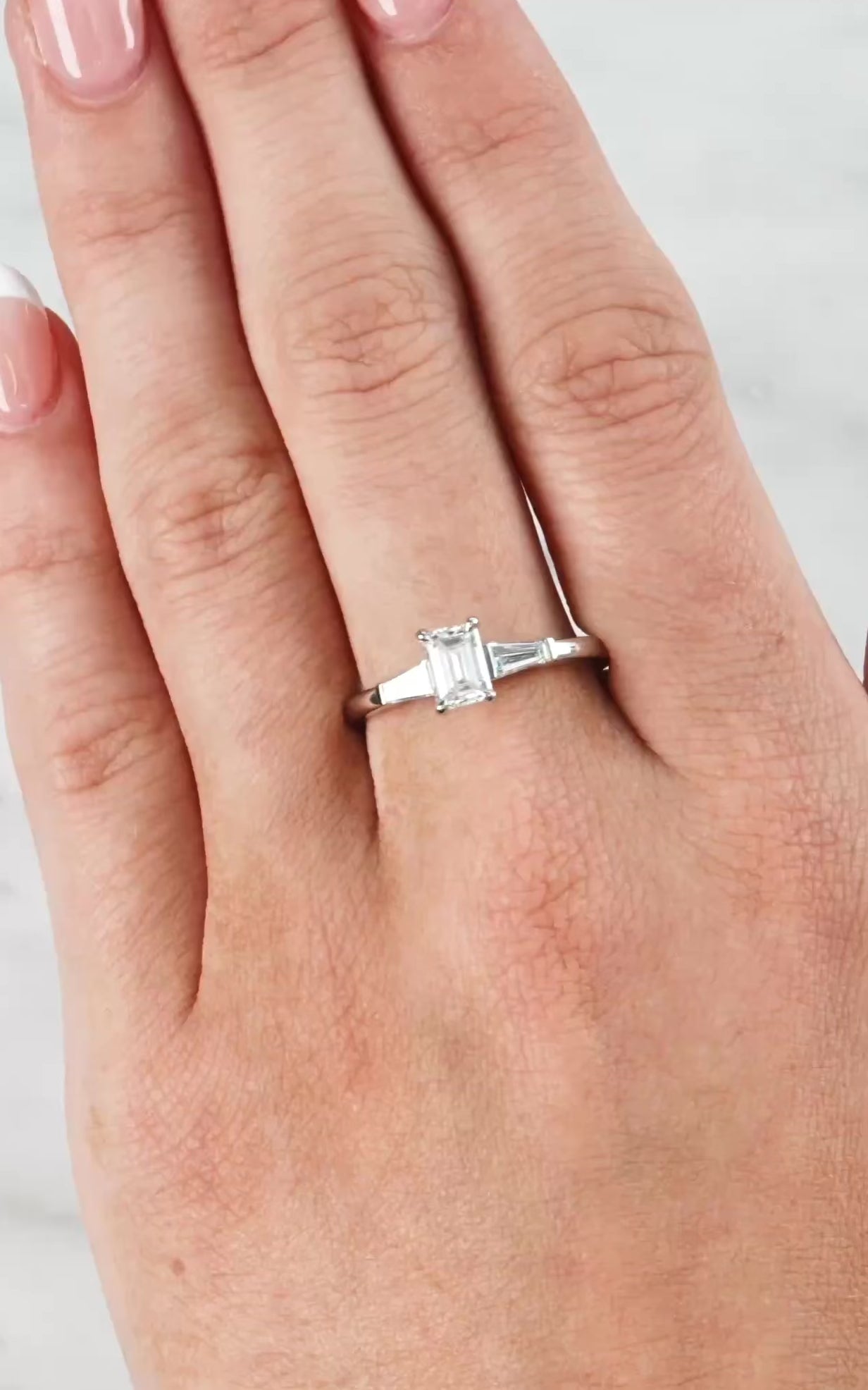 Lady wearing a Emerald Cut Diamond & Baguette Diamond Ring set in 18ct White Gold