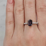 Hand wearing a ring with a purple gemstone on a light background at LeGassick Showroom.