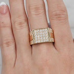 Gold ring with diamonds on a hand against a light background at LeGassick Showroom.