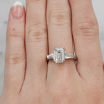 Hand wearing a diamond ring with a light grey background at LeGassick.