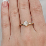 hand wearing a Gold ring with a pear-shaped diamond on a white background